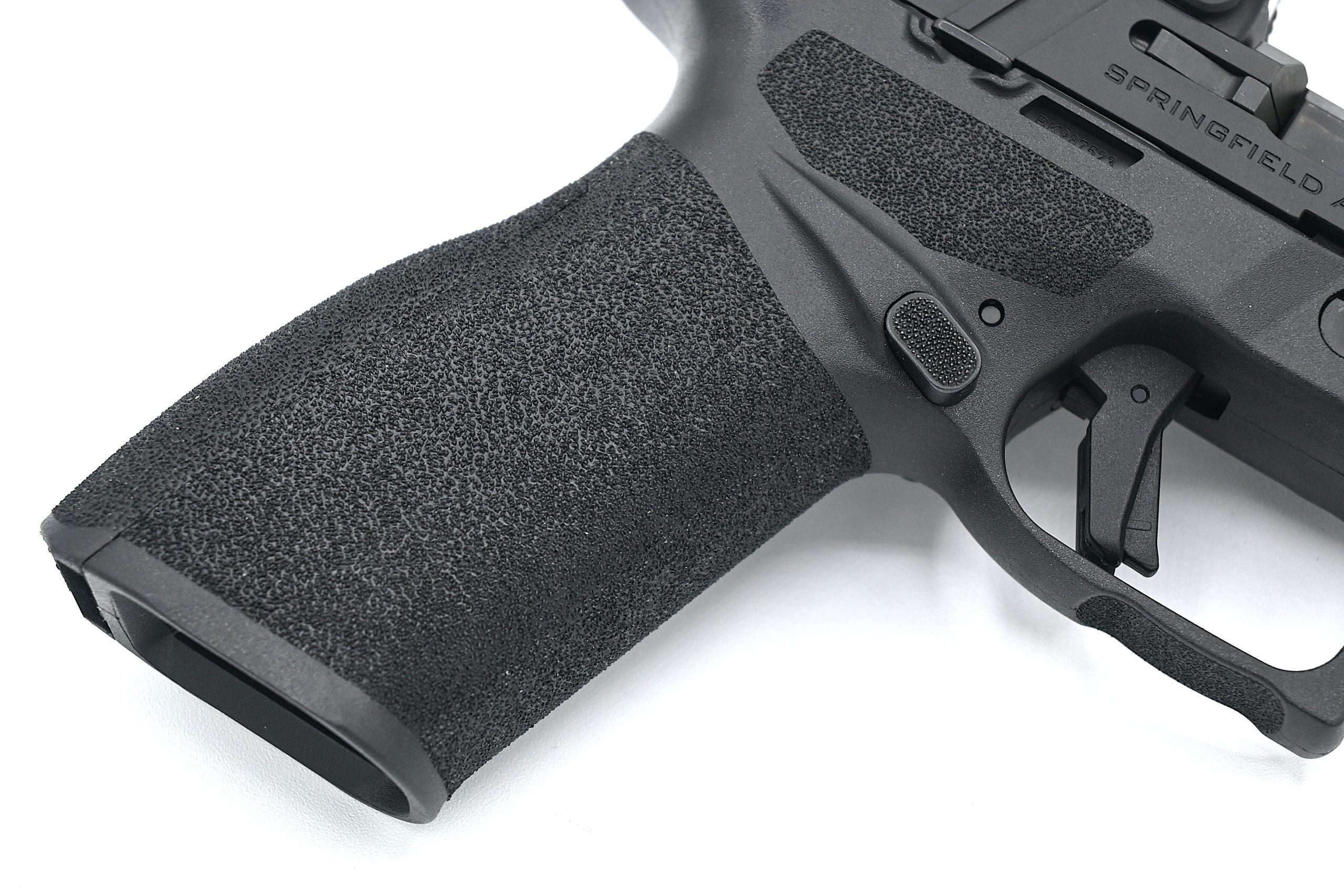 Springfield's Adaptive Grip Texture uses a staggered pyramid pattern that grips aggressively under recoil without abrading skin during extended carry.