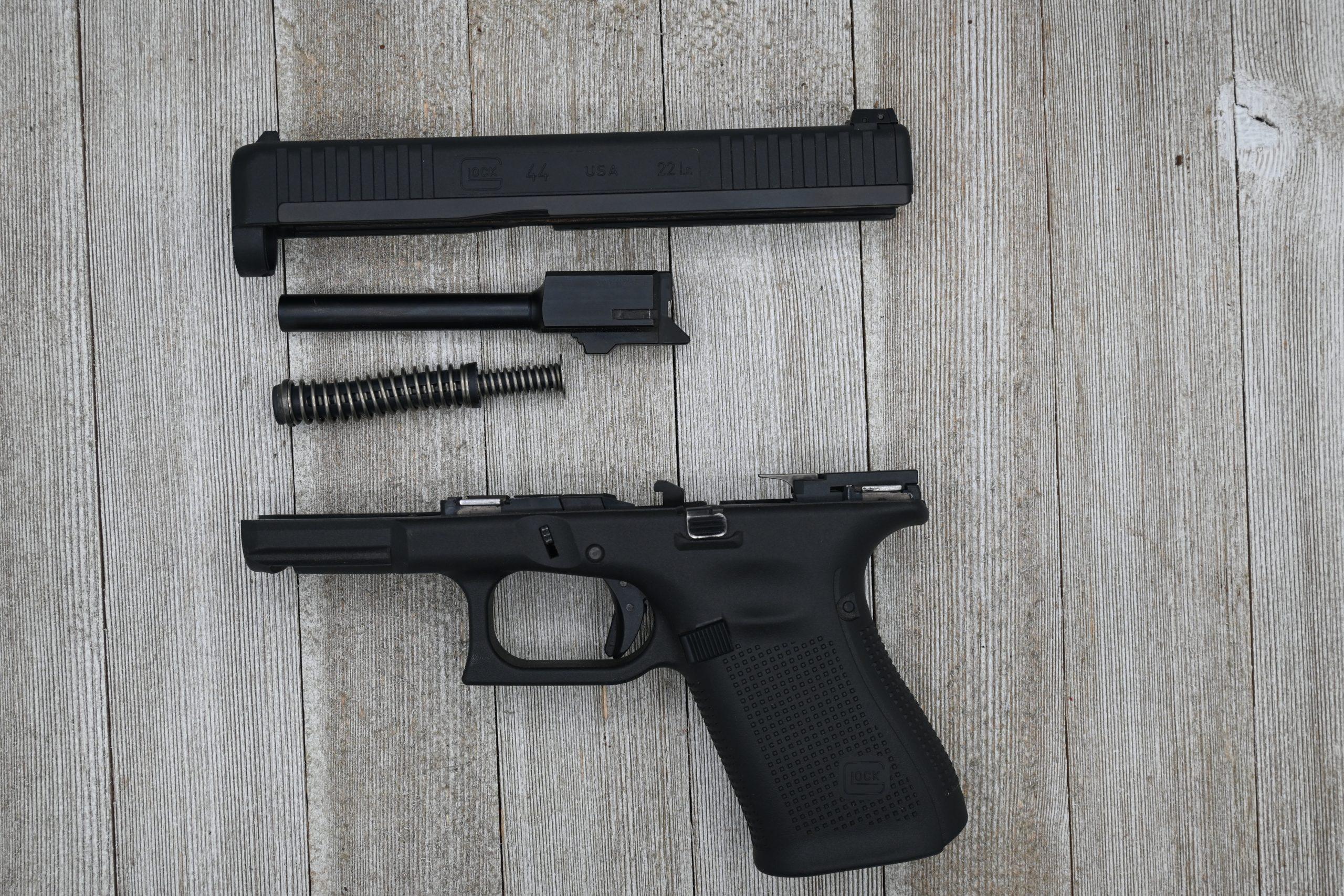 Glock 44 field-stripped showing hybrid polymer slide, steel insert, barrel, and recoil spring.