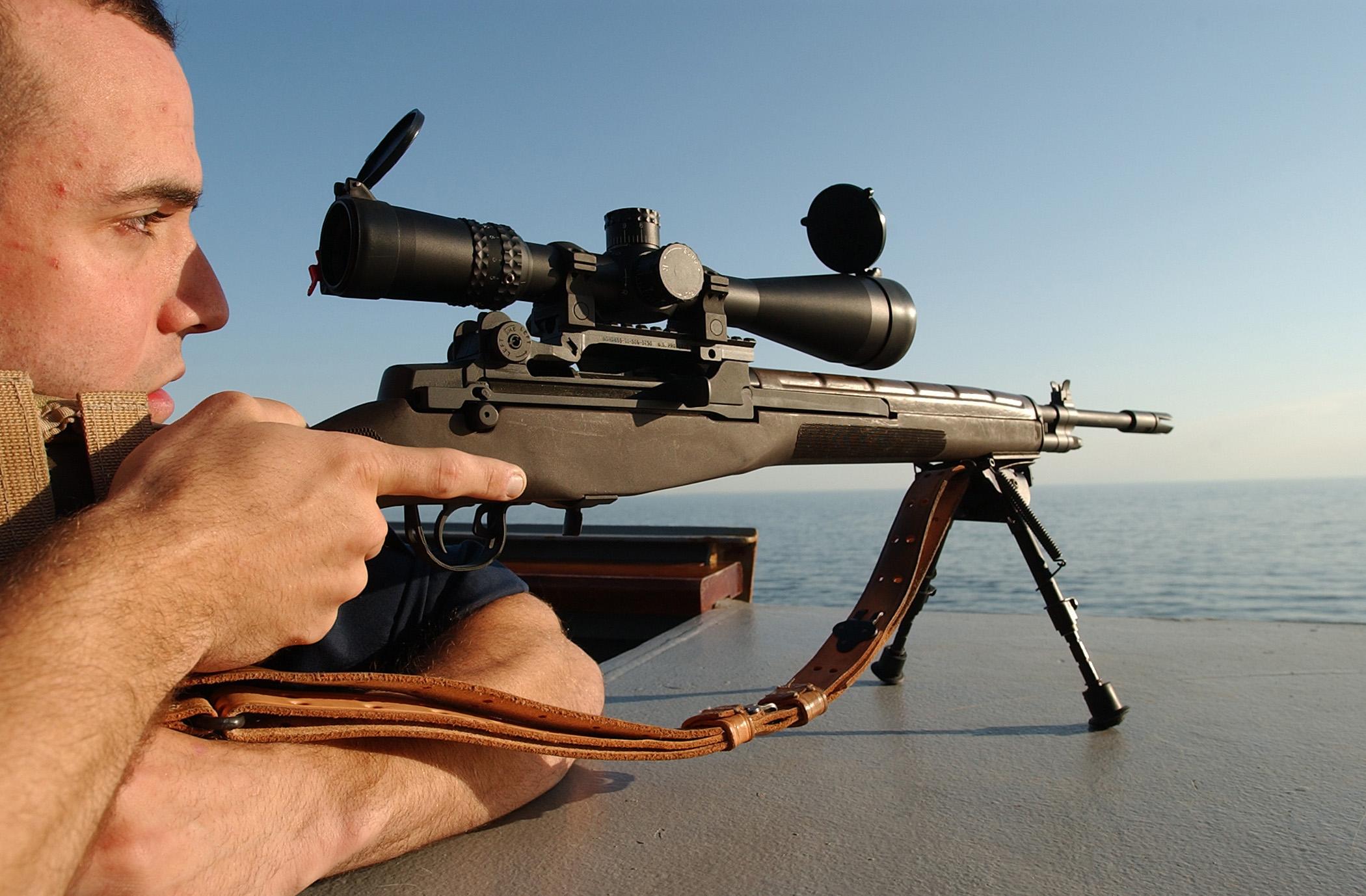 Ensign Jeremy M. Smith, a communications officer assigned to the guided-missile destroyer USS Mahan (DDG 72), takes aim with an M-14 sniper rifle.