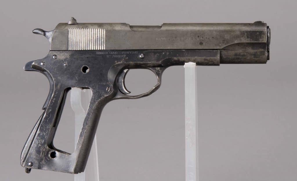 A "transitional" Colt M1911, serial number 708108, tracing its production to 1924. While it has several M1911A1 features such as the arched mainspring housing, short trigger, and cutaway trigger guard, it also is marked M1911 rather than M1911A1 and carries a blued finish. The pistol, recovered from the destroyer USS Shaw at Pearl Harbor, was damaged in the Japanese attack and is today part of the National Park Service's collection.