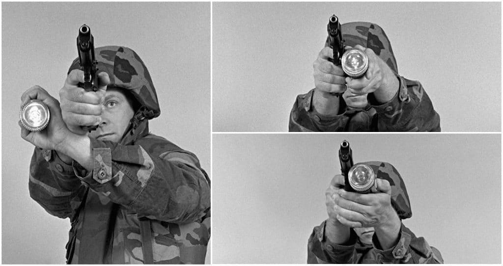 A Marine demonstrates a standing firing position with an M-9 9mm pistol and a flashlight, circa 1989. Three common positions-- Neck Index, Modified FBI, and Harries-- coupled with the old "lantern" position of holding the light overhead, were standard training for security and police throughout the 1970s, 80s, and 90s and are still valid today when using a standalone light in conjunction with a pistol.