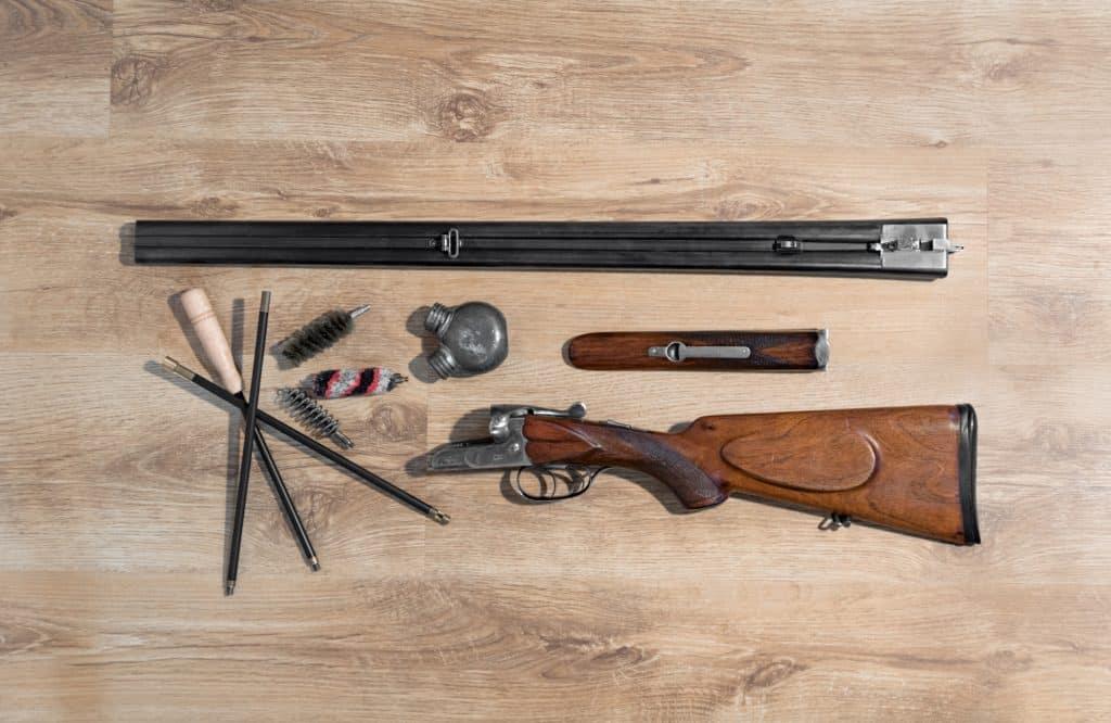 old double-barreled shotgun, disassembled, gun cleaning set, oiler, ramrod