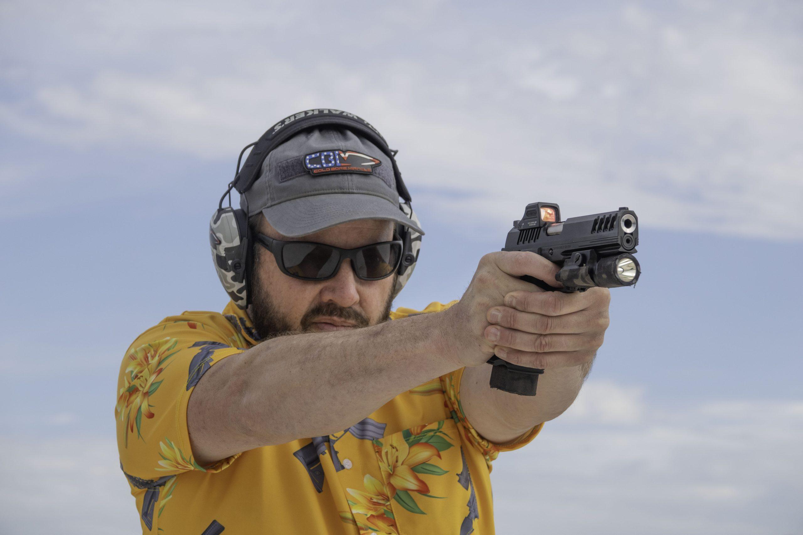Settling the sight picture on the Bersa M2Xi's Holosun red dot during field testing.